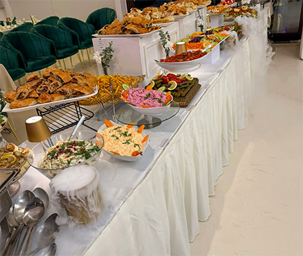 Reichhaltiges türkisches Buffet mit verschiedenen Meze-Salaten, gefüllten Weinblättern (Sarma), Börek und frischen Salaten, angerichtet mit dekorativem Trockeneis-Nebel.